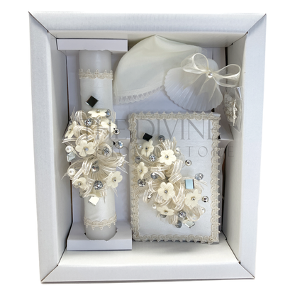 The image features a beautifully designed 5-piece baptism candle set, including a candle, a towel, rosary, bible and a shell. The candle is adorned with white fabric, a braided nylon rope, small white flowers, and rhinestone embellishments, pearl beads, and mirror pieces  giving it an elegant and sacred look. 