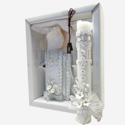 The image features a beautifully designed 6-piece baptism candle set, including a candle, a towel, rosary, bible, scapular, and a shell. The candle is adorned with white fabric, a braided nylon rope design, small white flowers, ribbon and rhinestone embellishments, giving it an elegant and sacred look. 