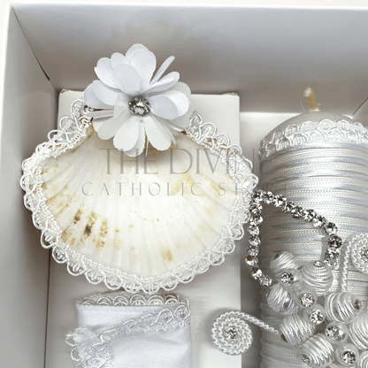 Close up image of the 3 piece baptism candle set shell, embroidered in white nylon thread, and white flower with white bead and rhinestone.