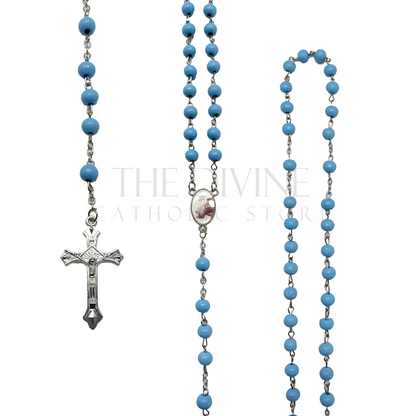 Close up detailed view of one of the rosaries in the 12 ct  blue baptism rosary party favor pack, each rosary has blue wooden beads, silver crucifix, and baptism image pendant as a reminder of the baptism even.