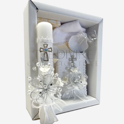 The image features a beautifully designed 5-piece baptism candle set, including a candle, a towel, rosary, bible and a shell. The candle is adorned with white fabric, a braided nylon rope, small white flowers, and rhinestone embellishments, giving it an elegant and sacred look. 