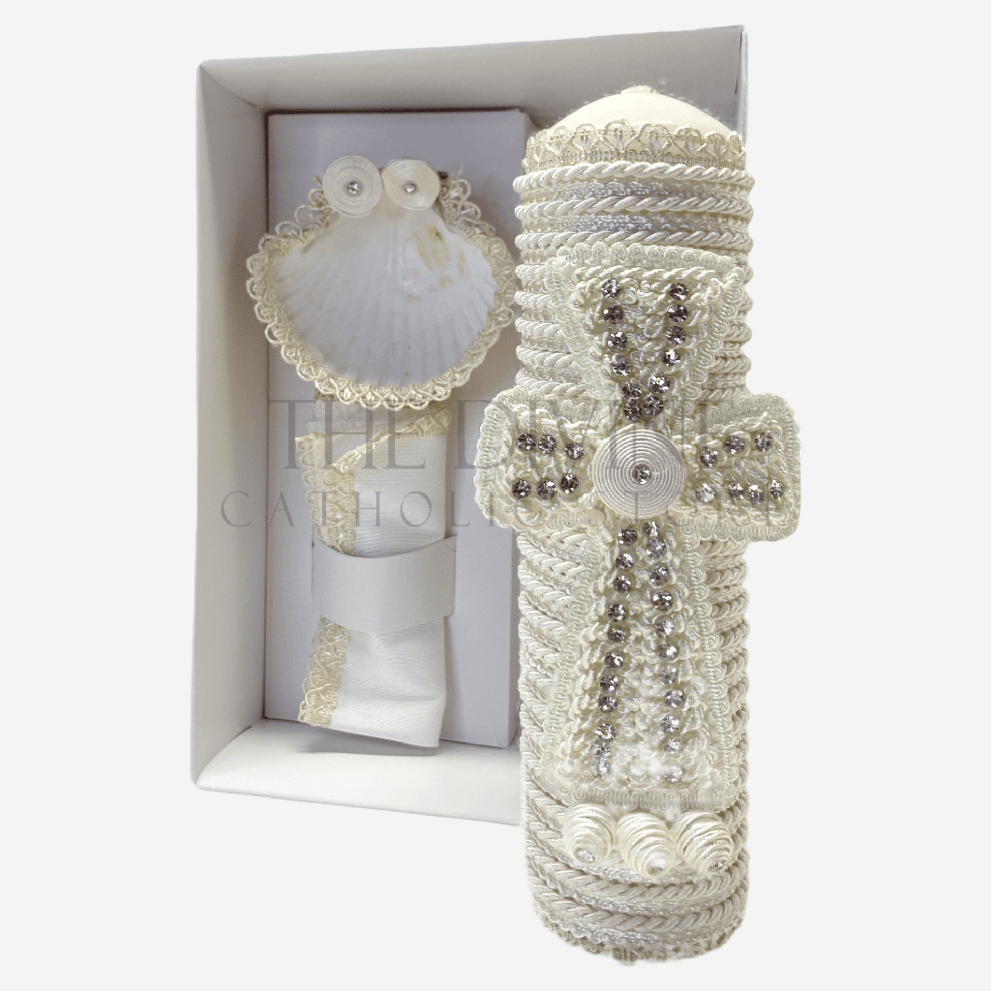 The image features a beautifully designed 3-piece baptism candle set, including a candle, a towel, and a shell. The candle is adorned with white fabric, a braided nylon rope, small white flowers, and rhinestone embellishments, giving it an elegant and sacred look. The towel and shell complement the set, creating a cohesive design perfect for a baptism ceremony.