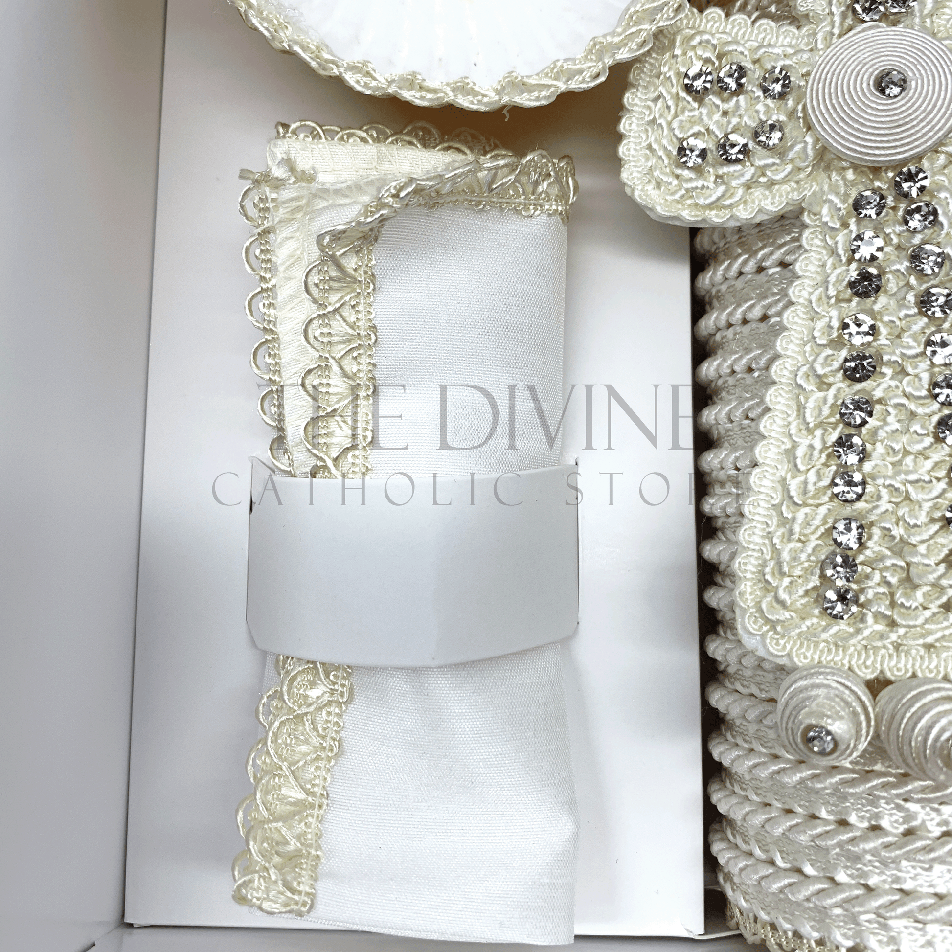 Close up of the 3 piece baptism candle set white fabric towel, embroidered in white nylon thread.